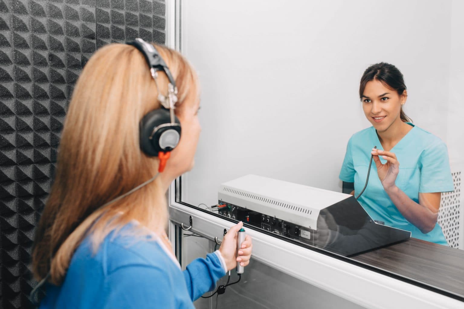 Female audiologist performing a hearing test for a female patient